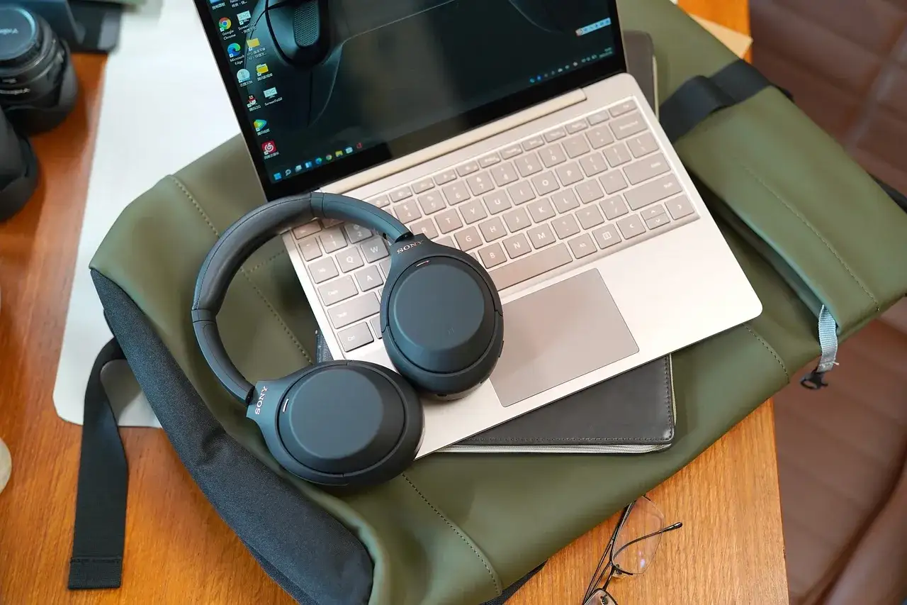 Laptop z włączonym Bluetooth, słuchawki bezprzewodowe w trybie parowania